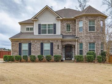 Beautiful two-story brick home featuring a turret, manicured bushes, and a well-kept lawn at 600 Lockerbie Ter, Mcdonough, GA 30252