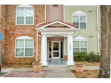 Inviting condo entrance featuring classic architecture, landscaped surroundings, and prominent building number at 1965 Nocturne Dr # 1305, Alpharetta, GA 30009