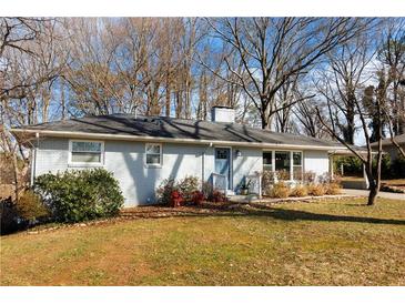 Charming single-story home featuring blue door, landscaped yard, and white painted brick at 2436 Elmwood Se Cir, Atlanta, GA 30339