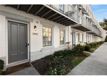 Charming townhome with painted brick, metal balconies, and landscaped front yard at 304 Stonemont Dr, Atlanta, GA 30305