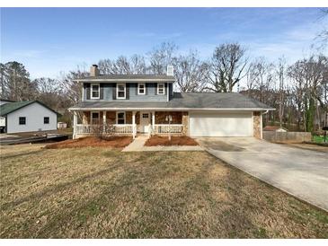 Charming two-story home featuring stone accents, a welcoming front porch, and a well-maintained front yard at 7330 White Flag Trl, Lithia Springs, GA 30122