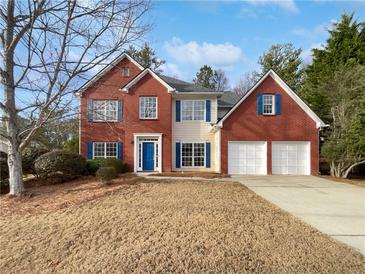 Traditional two-story home featuring a brick facade, blue shutters, and a well-manicured lawn at 730 Taylor School Dr, Lawrenceville, GA 30043