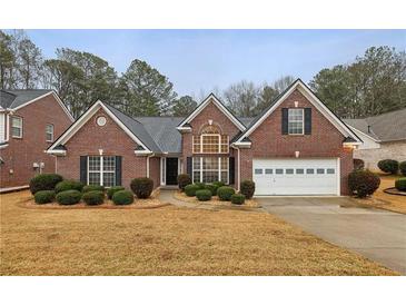 Charming brick home featuring a well-manicured lawn and attached garage, perfect for suburban living at 1135 Chandler Ridge Dr, Lawrenceville, GA 30045