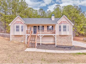 Charming home featuring a cozy porch with stone accents and manicured landscaping at 171 W Fork Way, Temple, GA 30179