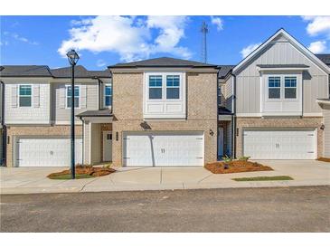 Charming townhome featuring a one-car garage and brick accents at 312 Shine Dr, Stockbridge, GA 30281