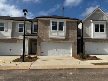 Charming brick townhome with two-car garage and inviting curb appeal at 312 Shine Dr, Stockbridge, GA 30281