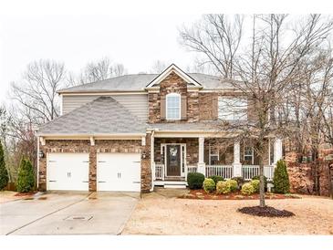 Charming two-story home with a brick and stone facade, a well-manicured lawn, and an inviting front porch at 428 Providence Walk St, Canton, GA 30114