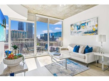 Bright living room with city views, modern decor, and a comfortable seating area at 860 Peachtree Ne St # 1008, Atlanta, GA 30308