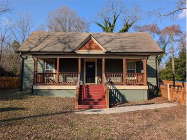 Charming home featuring a covered front porch with decorative wooden supports and red stairs leading to the front door at 3124 Usher Nw St, Covington, GA 30014