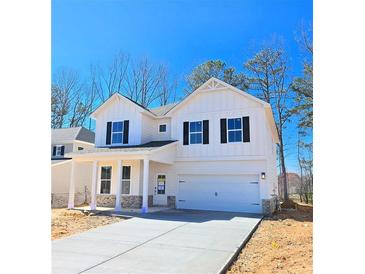 Charming two-story white farmhouse featuring a two car garage and welcoming front porch at 2371 Brown Dove Way Lot 4, Grayson, GA 30017