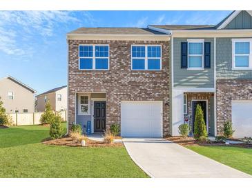Charming brick townhome featuring a well-manicured lawn and attached one car garage at 579 Magnolia Cir, Palmetto, GA 30268
