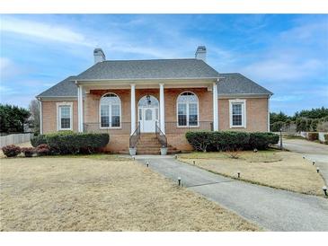 Charming brick home featuring a manicured lawn and covered front porch with classic columns at 2860 Chardonnay Ln, Cumming, GA 30041