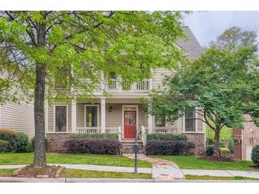 Charming two-story home boasts a covered porch, stone accents, and a lush landscaped front yard at 1624 Duncan Nw Dr, Atlanta, GA 30318