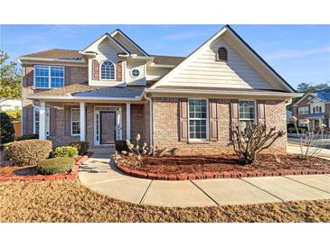 Charming two-story brick home with a well-manicured lawn and covered front porch at 4556 Creekside Cv, Atlanta, GA 30349