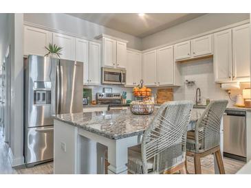 Bright kitchen features white cabinets, stainless steel appliances, granite countertops, and barstool seating at 530 Vandenburg Dr, Villa Rica, GA 30180