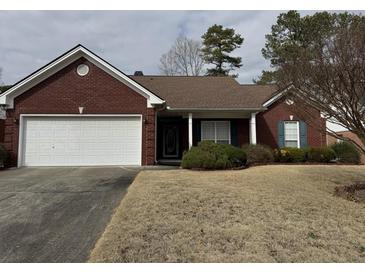 Lovely brick home featuring an attached garage and well-maintained lawn at 2690 Freemans Walk Dr, Dacula, GA 30019