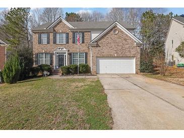Charming two-story brick home featuring a two-car garage and manicured lawn at 4002 Forest Grove Nw Pass, Acworth, GA 30101