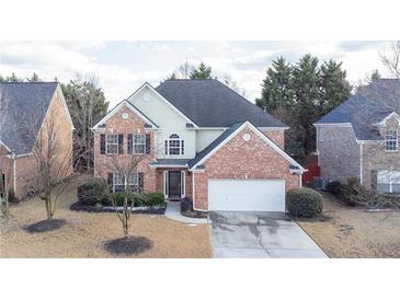 Charming two-story brick home with attached two-car garage, mature landscaping, and a well-maintained yard at 480 Glenns Farm Way, Grayson, GA 30017