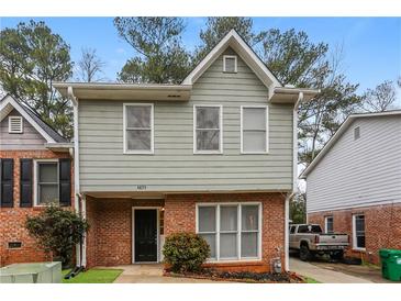 Charming two-story home with a brick facade, gray siding, and well-maintained landscaping at 4893 Autumn Cir, Stone Mountain, GA 30088