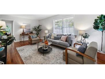 Bright living room with hardwood floors, a large window and a comfortable seating arrangement at 1943 Main Nw St, Atlanta, GA 30318