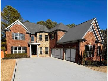 Beautiful brick home with a three car garage and a well-maintained lawn at 3499 Lake Mill Rd, Buford, GA 30519