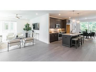 Open floor plan with hardwood floors connecting the living room, kitchen and dining area at 388 Pratt Se Dr # 2134, Atlanta, GA 30315