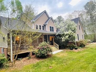 Charming two-story home with front porch and beautifully landscaped front yard surrounded by mature trees at 718 Fincher Rd, Covington, GA 30016