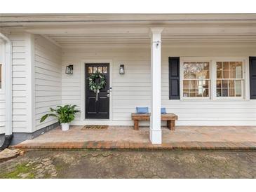 Charming covered front porch with brick flooring and wooden bench seating, perfect for relaxing at 2508 Brookwood Ne Dr, Atlanta, GA 30305