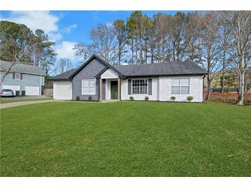 Charming home with lush green lawn, manicured landscaping, and welcoming curb appeal at 2964 Hollow Ln, Powder Springs, GA 30127