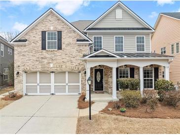 Charming two-story brick and siding home with an attached two-car garage and welcoming covered porch at 3650 Bentbill Xing, Cumming, GA 30041