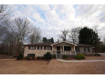 Charming single-story brick home featuring a covered porch and well-maintained front yard at 4973 Horton Pl, Douglasville, GA 30135