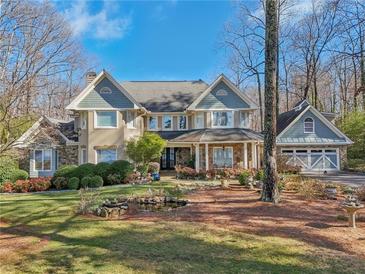 Beautiful home with professionally landscaped front yard, water feature, and attached garage at 9865 Buice Rd, Alpharetta, GA 30022