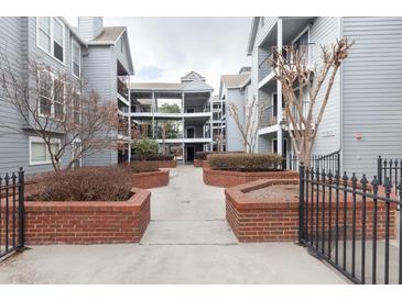 Condominium complex featuring well-maintained courtyard with brick planters and manicured landscaping at 602 Granville Ct, Sandy Springs, GA 30328