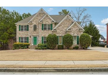 Charming two-story brick home featuring manicured landscaping and traditional architectural details at 1412 Great Shoals Dr, Lawrenceville, GA 30045