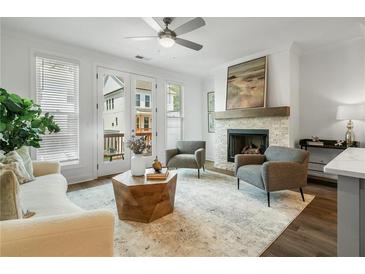 Bright living room features a fireplace, neutral decor, modern furnishings, and access to an outdoor space at 2390 Edgar Park Pl # 102, Duluth, GA 30096