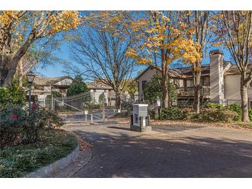 Gated community entrance featuring mature trees and colorful landscaping at 44 Finch Ne Trl, Atlanta, GA 30308