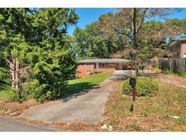 Traditional one-story home with a brick facade and a long driveway at 2837 Davidson Dr, Lithonia, GA 30058