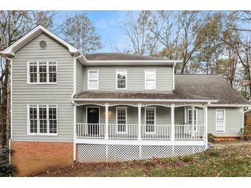 Charming two-story home with a large, inviting front porch and traditional architectural details at 145 Price Hills Ct, Sugar Hill, GA 30518