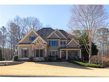 Stunning front exterior of home showcasing stone accents and a meticulously maintained front yard at 4095 Copper Leaf Ln, Cumming, GA 30040