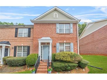 Charming two-story brick townhouse with well-manicured front yard and light blue shutters at 1976 Drennon Ave, Austell, GA 30106