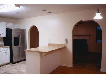 Cozy kitchen featuring stainless steel appliances and a breakfast bar overlooking an arched doorway and hardwood floors at 3736 Soapstone Rd, Decatur, GA 30034