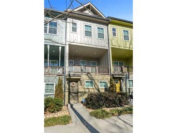 Charming townhome featuring a covered balcony, decorated door and manicured landscaping at 68 Adore Se Ct, Atlanta, GA 30315