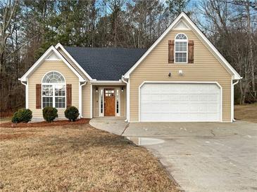 Charming home featuring a manicured lawn, a two-car garage, and a welcoming front entrance with detailed trim work at 155 Shenandoah Ct, Hiram, GA 30141