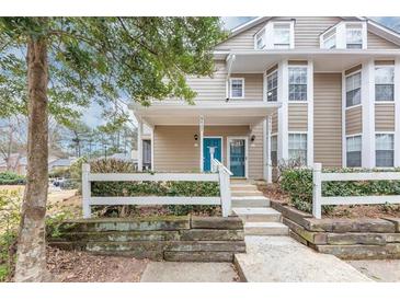 Charming townhome with a bright blue front door and a well-maintained white picket fence at 6422 Pinebark Way, Morrow, GA 30260