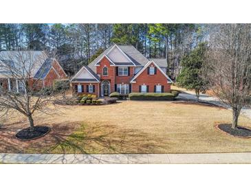 Charming two-story brick home with manicured lawn and beautiful landscaping at 1027 Eagles Brooke Dr, Locust Grove, GA 30248