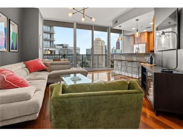 Bright living room featuring a comfortable sofa and floor-to-ceiling windows with beautiful views of the city skyline at 1080 Peachtree Ne St # 2108, Atlanta, GA 30309