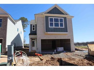 New home exterior elevation showing brick facade, blue siding, and attached two-car garage at 1975 William Glen St, Dacula, GA 30019