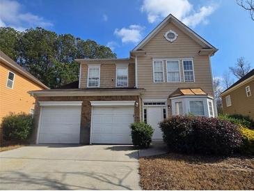 Inviting two-story home with attached two-car garage and manicured landscaping at 7330 Taloga Ln, Union City, GA 30291