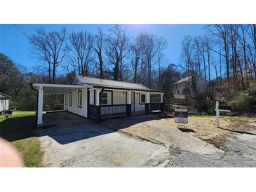 Charming home with a cozy porch, black railing, covered parking, and a 'For Sale' sign at 2322 Ewing Sw St, Atlanta, GA 30331