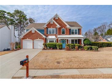 Beautiful two-story brick home with a manicured front yard and two-car garage at 243 Wedmore Ct, Suwanee, GA 30024